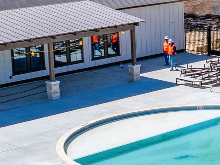 amenity-center-general-contractors-in-san-antonio-walking-by-newly-built-pool-and-recreation-center amenity center general contractors in-san antonio walking by newly built pool and recreation center
